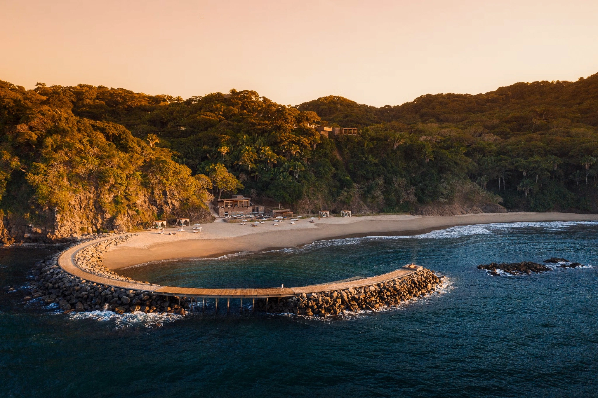 Curved beachfront boardwalk at sunset at One&Only Mandarina, México